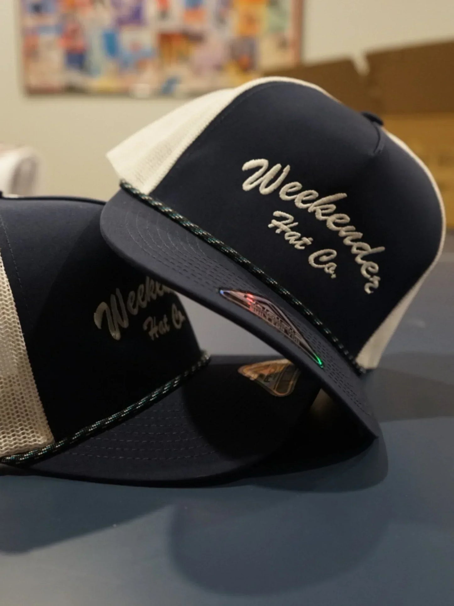 A photo of two navy trucker hats from Weekender Hat Co.