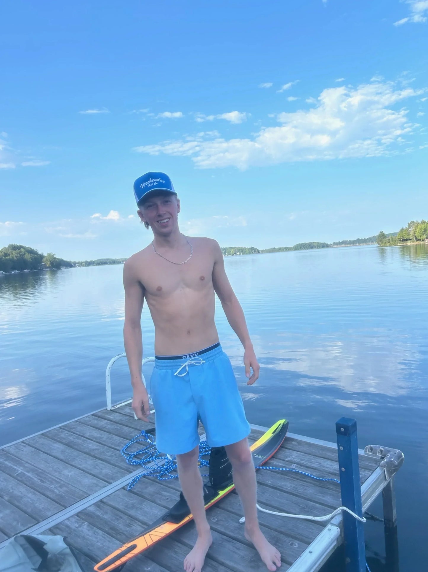 A photo of The Classic Weekender - Blue Trucker Hat being worn at the lake