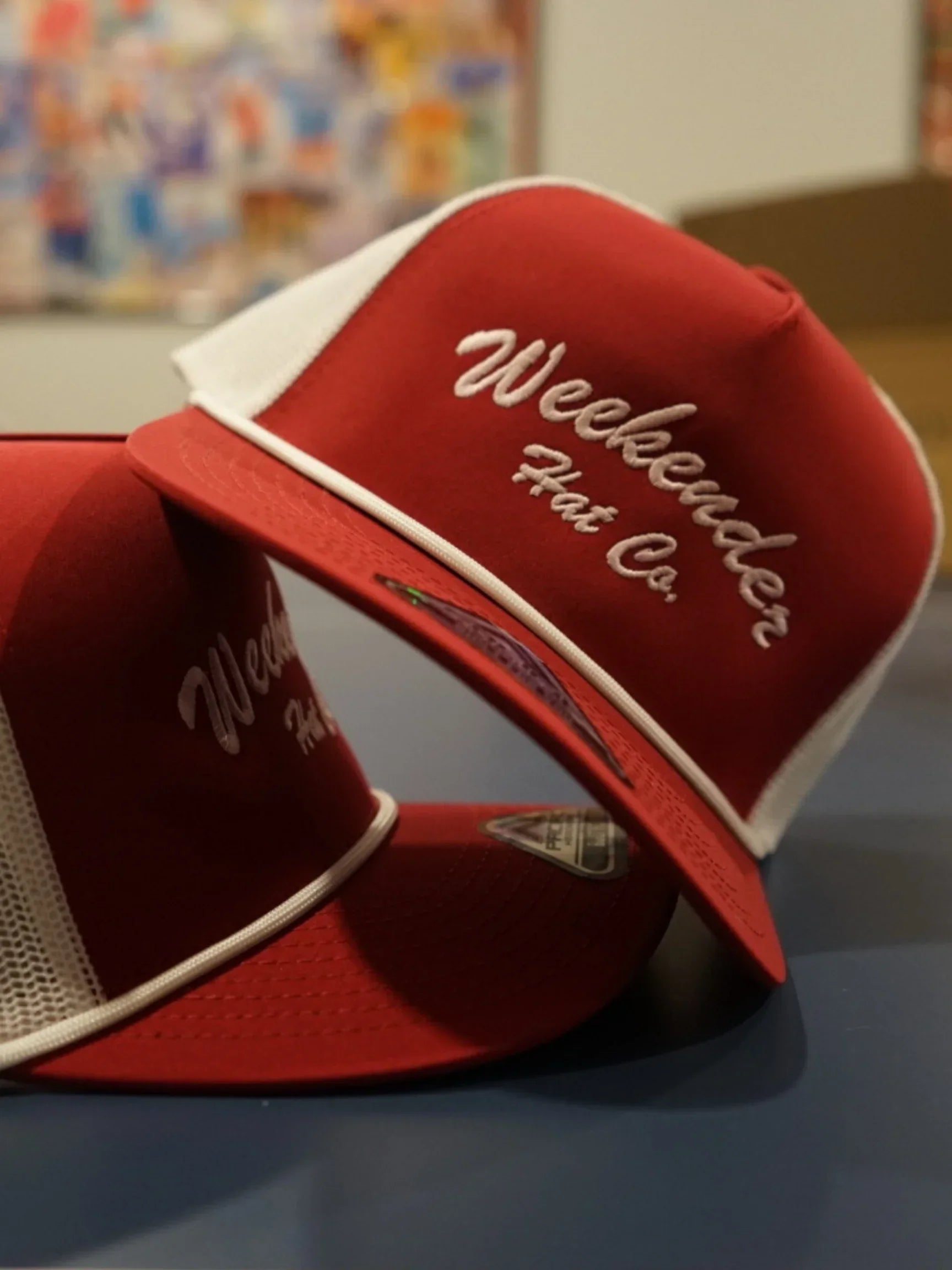 A photo of two red trucker hats - Weekender Hat Co.