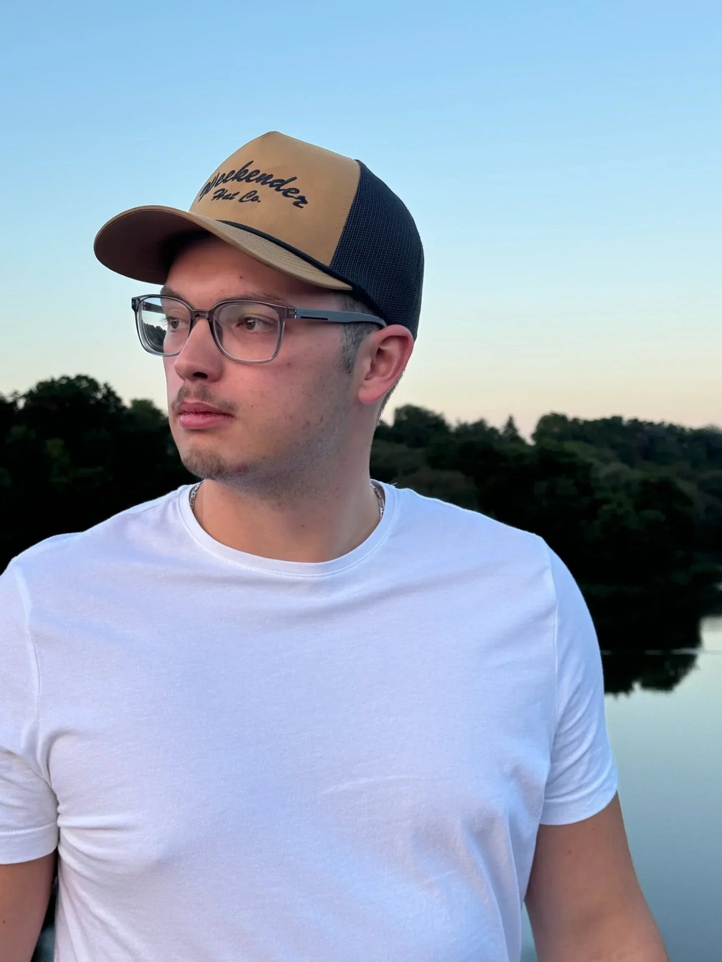 A photo of The Classic Weekender - Tan Trucker Hat being worn at the river