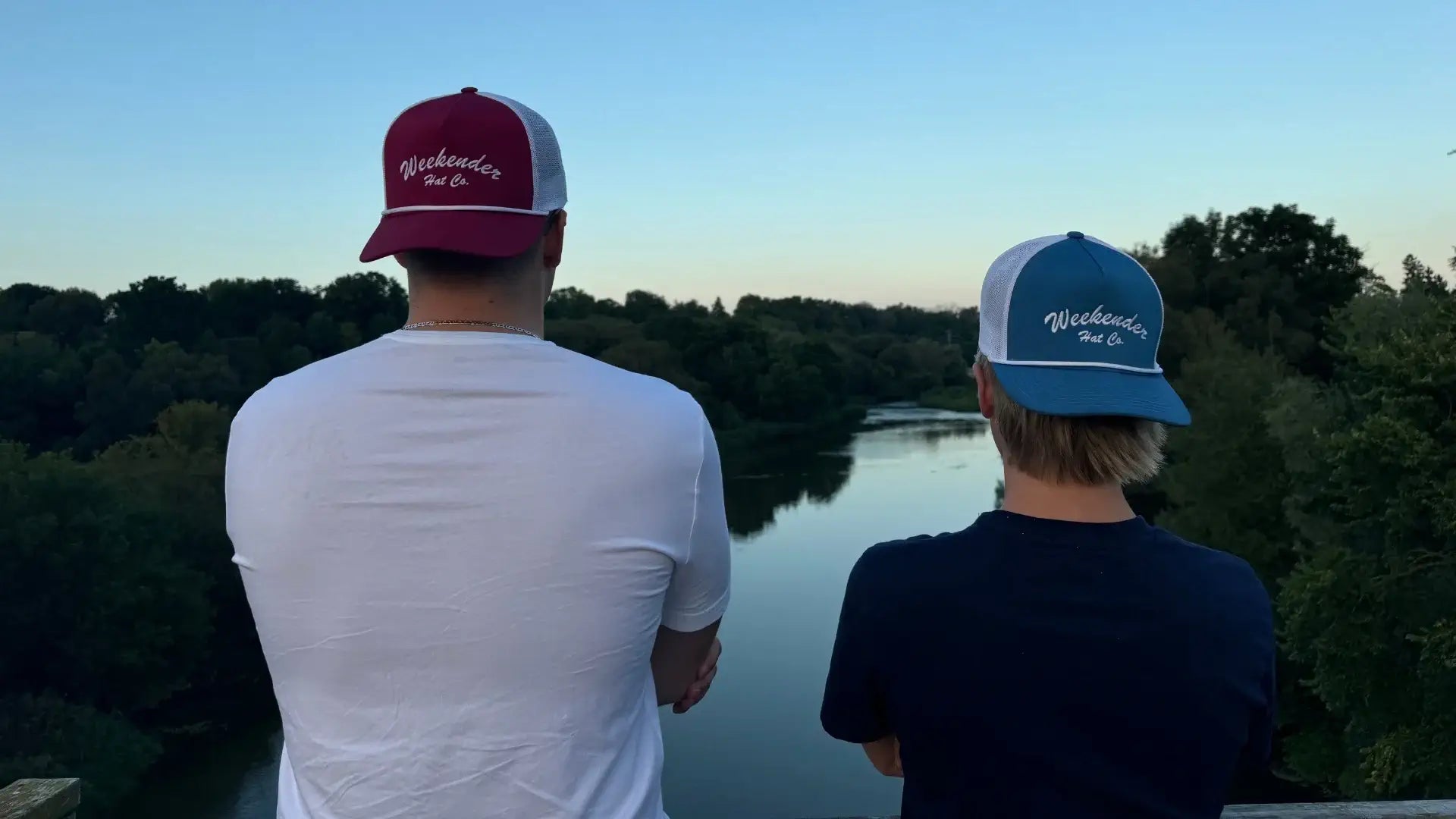 Red and blue Weekender trucker hats overlooking the river - Weekender Hat Co.